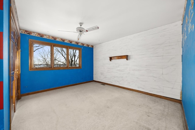 empty room featuring light colored carpet and ceiling fan