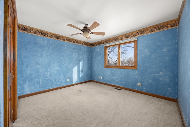 carpeted spare room featuring ceiling fan