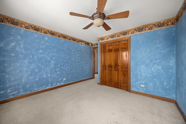 unfurnished bedroom featuring carpet floors, a closet, and ceiling fan