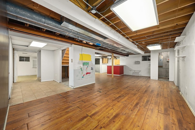 basement featuring hardwood / wood-style floors and electric panel