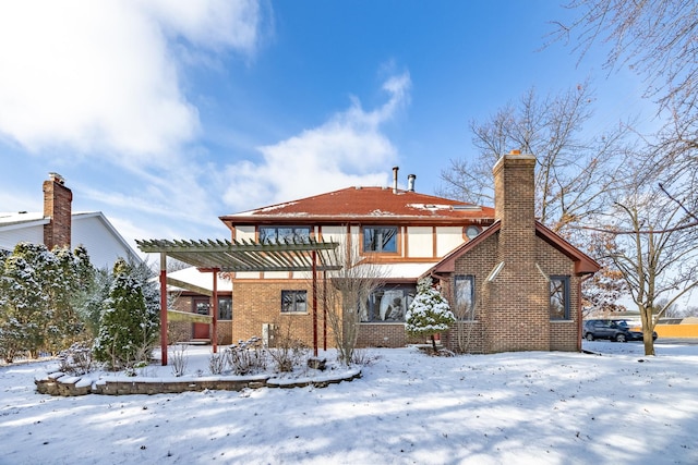 snow covered property with a pergola