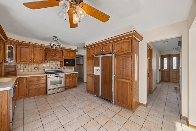 kitchen with light tile patterned flooring, stainless steel range oven, dishwasher, paneled fridge, and backsplash