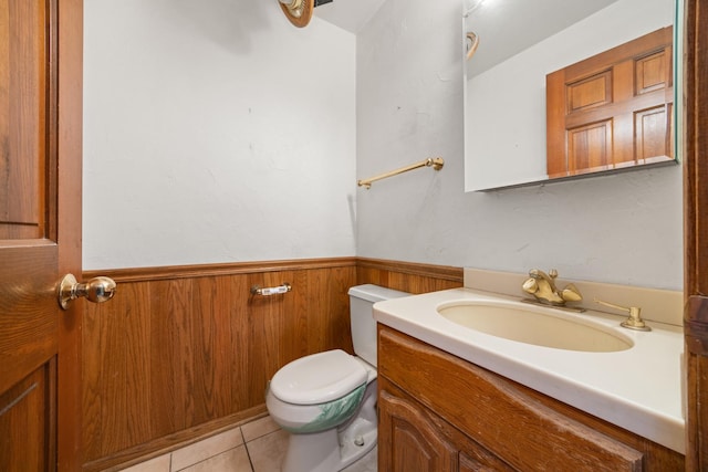 bathroom with vanity, tile patterned floors, wooden walls, and toilet