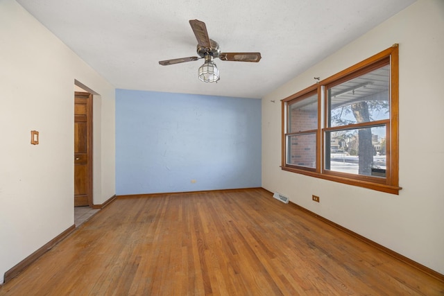 spare room with ceiling fan and light wood-type flooring