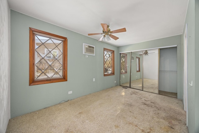 unfurnished bedroom with ceiling fan, carpet, a wall unit AC, and a closet