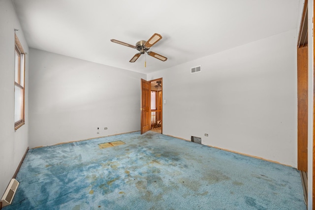 empty room with ceiling fan and carpet