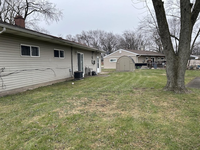 view of yard featuring central AC and a shed