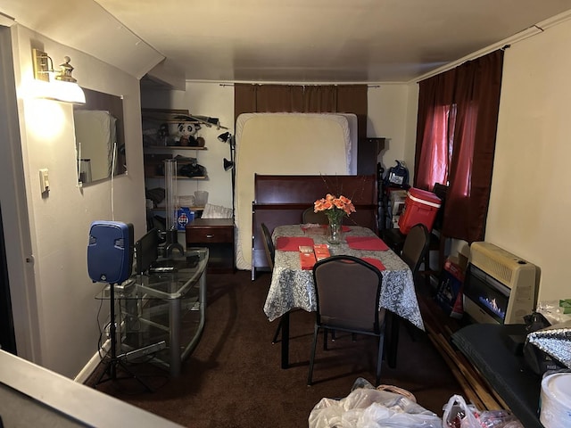 dining space with dark colored carpet and heating unit