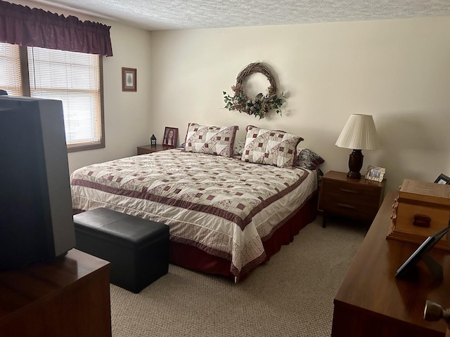 bedroom featuring light carpet and a textured ceiling