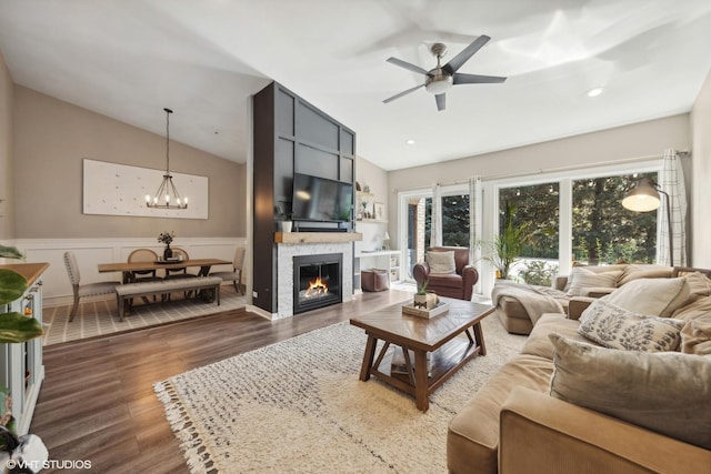 living room featuring vaulted ceiling, dark hardwood / wood-style floors, and ceiling fan with notable chandelier