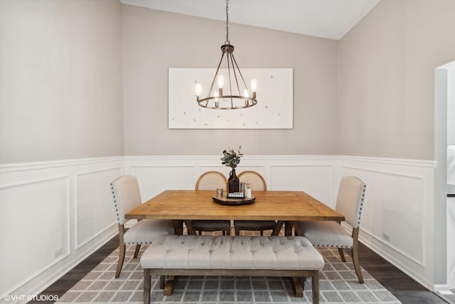 dining room with an inviting chandelier, lofted ceiling, and dark hardwood / wood-style flooring