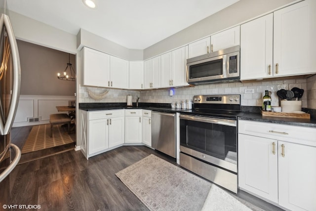 kitchen featuring backsplash, dark wood-type flooring, stainless steel appliances, and white cabinets