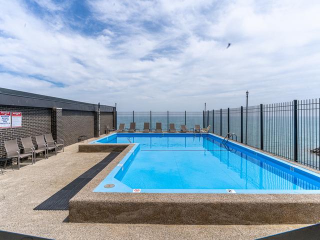 view of pool featuring a water view and a patio