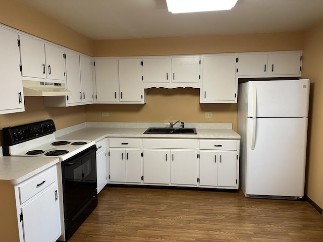 kitchen featuring white refrigerator, electric range oven, and white cabinets