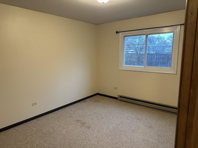 empty room featuring light carpet and baseboard heating