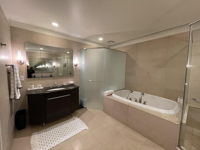 bathroom featuring vanity, tile patterned floors, shower with separate bathtub, and tile walls