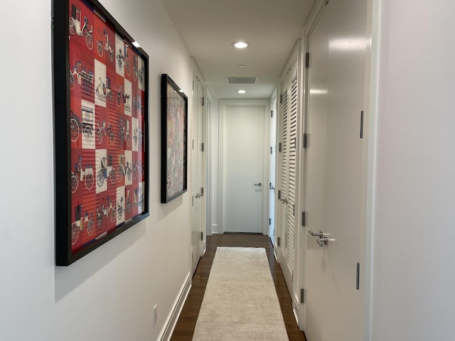 corridor with dark hardwood / wood-style flooring