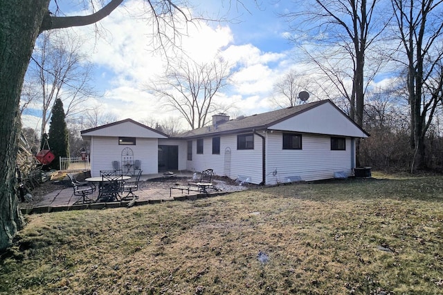 back of house featuring a lawn and a patio area