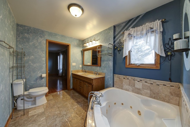 bathroom with vanity, tiled bath, and toilet