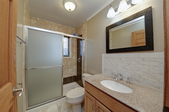 bathroom featuring vanity, toilet, a shower with shower door, and backsplash