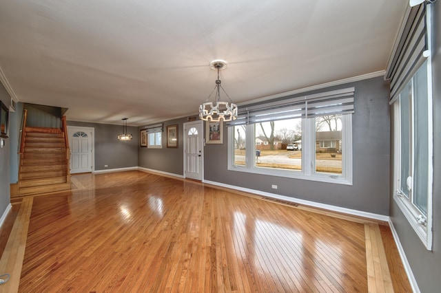 unfurnished dining area with a notable chandelier, wood-type flooring, and ornamental molding