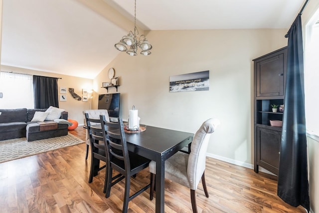 dining area featuring lofted ceiling with beams, baseboards, a chandelier, and wood finished floors