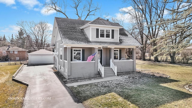 view of front of home featuring an outbuilding, a porch, a garage, and a front yard