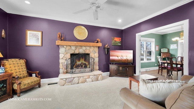 living room featuring crown molding, a fireplace, ceiling fan with notable chandelier, and carpet