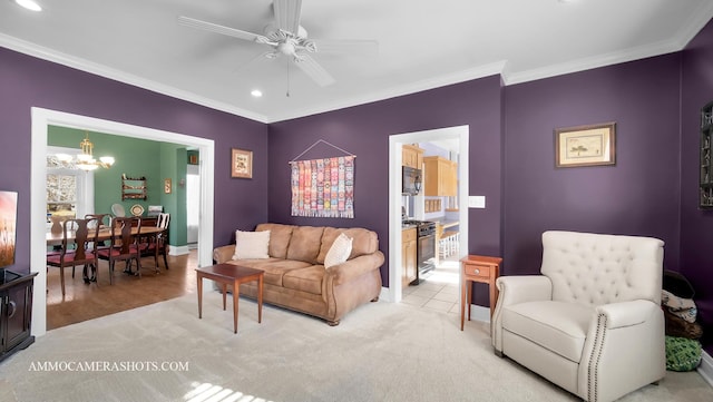 carpeted living room featuring ornamental molding and ceiling fan with notable chandelier