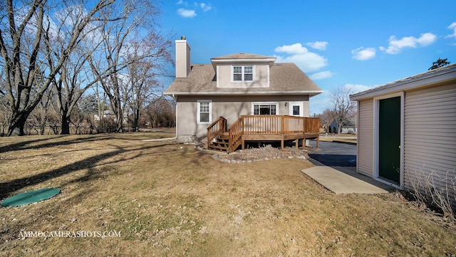 rear view of house featuring a lawn and a deck