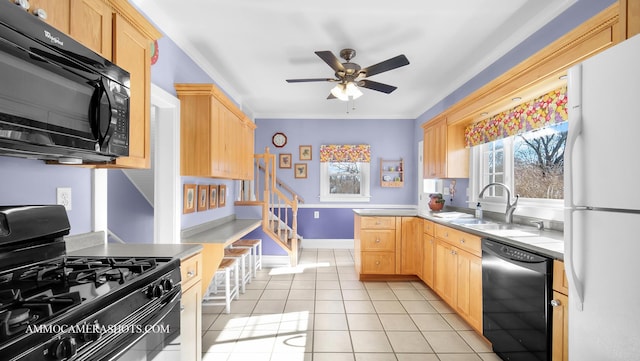 kitchen with light tile patterned floors, light brown cabinetry, sink, and black appliances