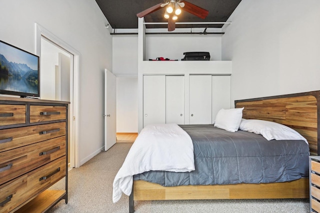 carpeted bedroom featuring multiple closets and a high ceiling