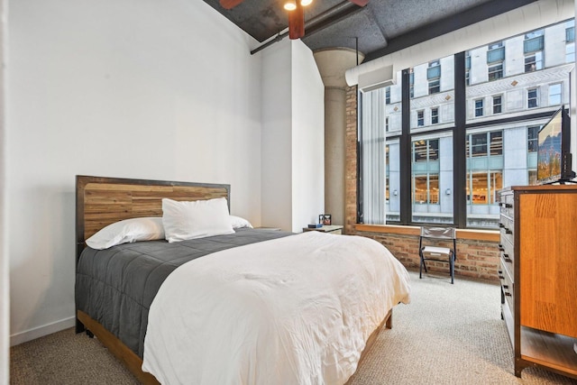 carpeted bedroom featuring brick wall