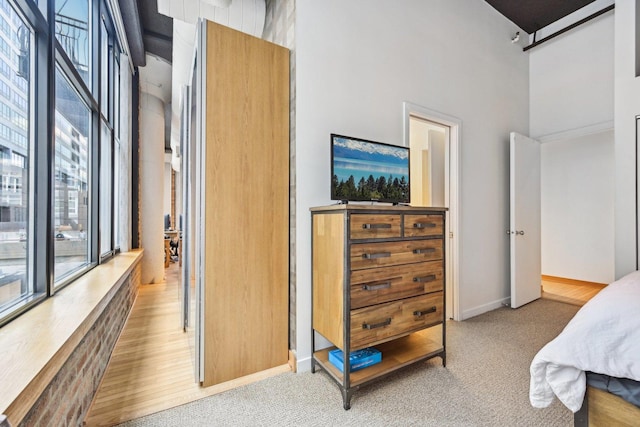 carpeted bedroom featuring a high ceiling