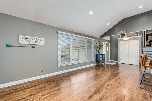 unfurnished room with hardwood / wood-style floors and high vaulted ceiling