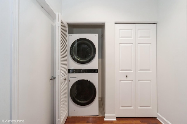 washroom featuring stacked washer / dryer and dark hardwood / wood-style floors