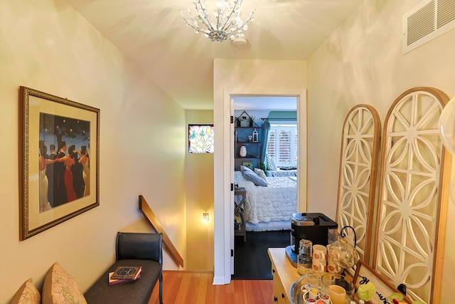 corridor with a notable chandelier and light hardwood / wood-style floors