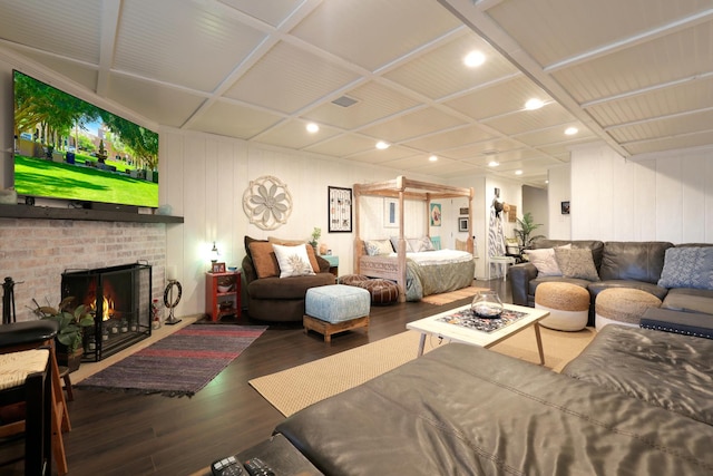 living room featuring a brick fireplace and dark wood-type flooring