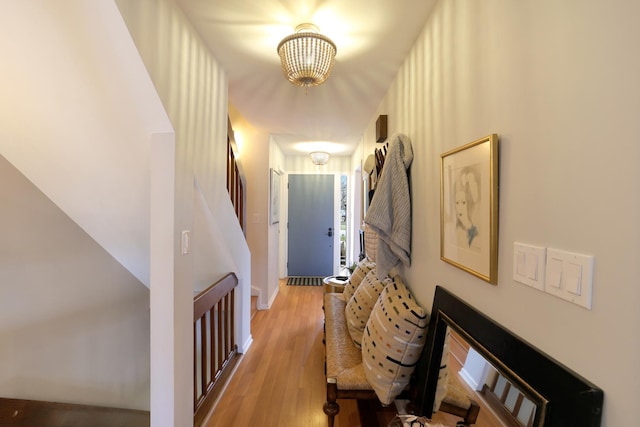 hallway featuring an inviting chandelier and light wood-type flooring