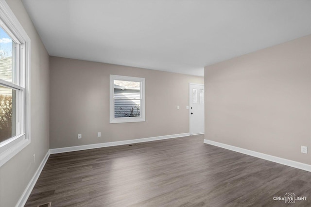 unfurnished room with plenty of natural light and dark hardwood / wood-style floors