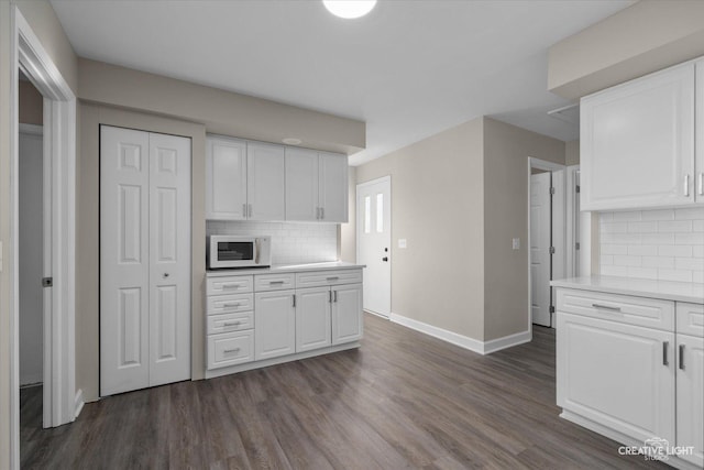 kitchen featuring white cabinetry, decorative backsplash, and dark wood-type flooring