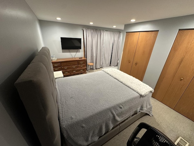 carpeted bedroom featuring multiple closets