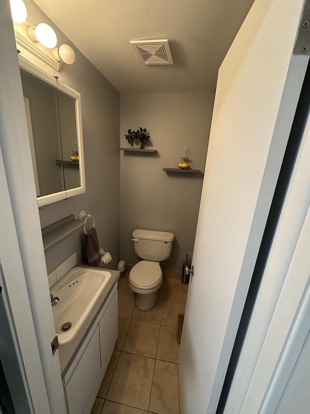 bathroom with tile patterned flooring, vanity, and toilet