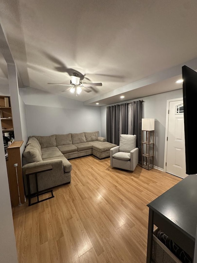 living room with ceiling fan and light wood-type flooring