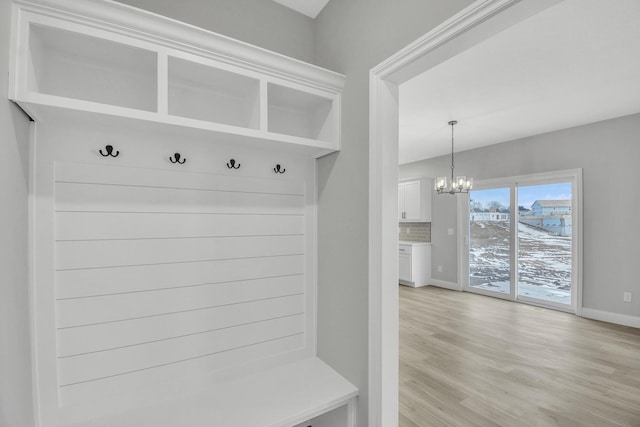 mudroom with a notable chandelier and light hardwood / wood-style flooring