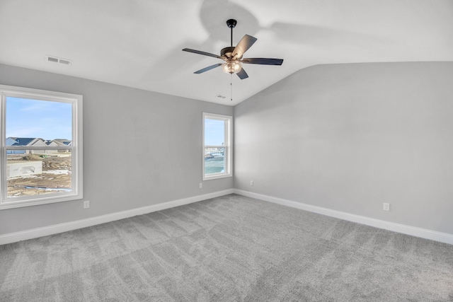 carpeted spare room featuring ceiling fan and lofted ceiling