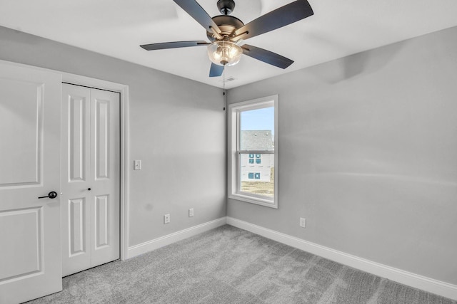 unfurnished bedroom with ceiling fan, a closet, and light carpet