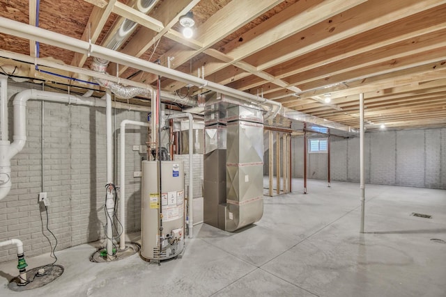 basement featuring water heater, brick wall, and heating unit