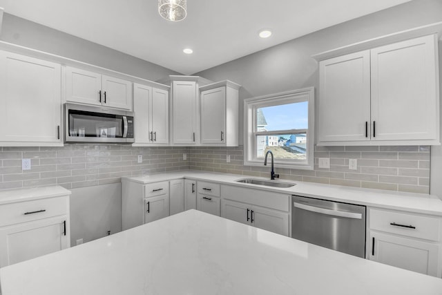 kitchen featuring white cabinetry, appliances with stainless steel finishes, sink, and decorative backsplash