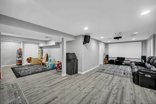 home theater room featuring visible vents, recessed lighting, wood finished floors, and baseboards